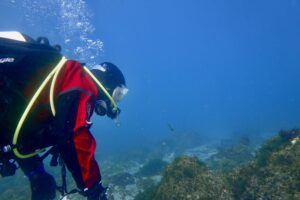 Kafari í rauðum galla í sjónum.